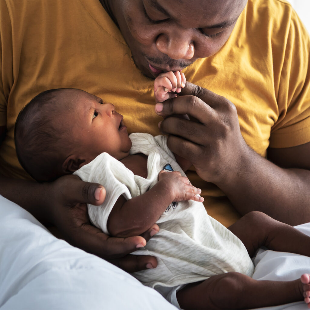 dad kissing newborns hand 1600x1600